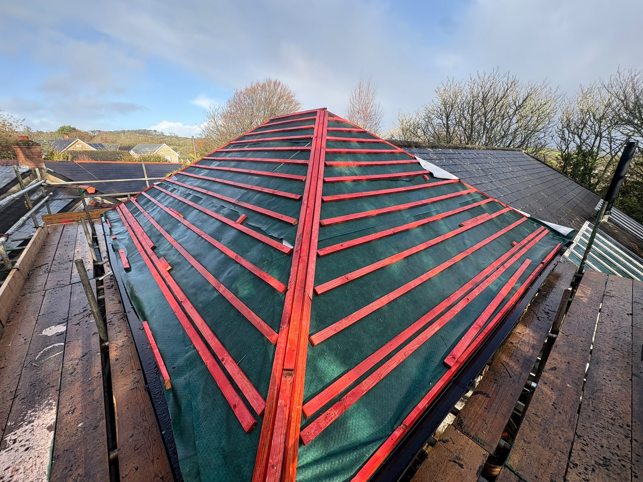 Hip roof battened in red timber over green breathable membrane by Check A Leak